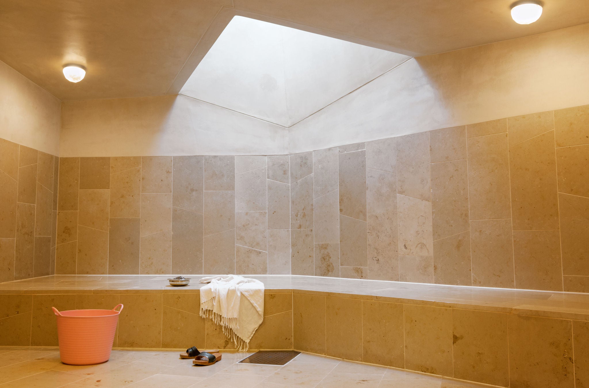 Raum des Hammam-Rundgangs mit Wassereimer und Foutah im Hammam Basar & Salon in Zürich.