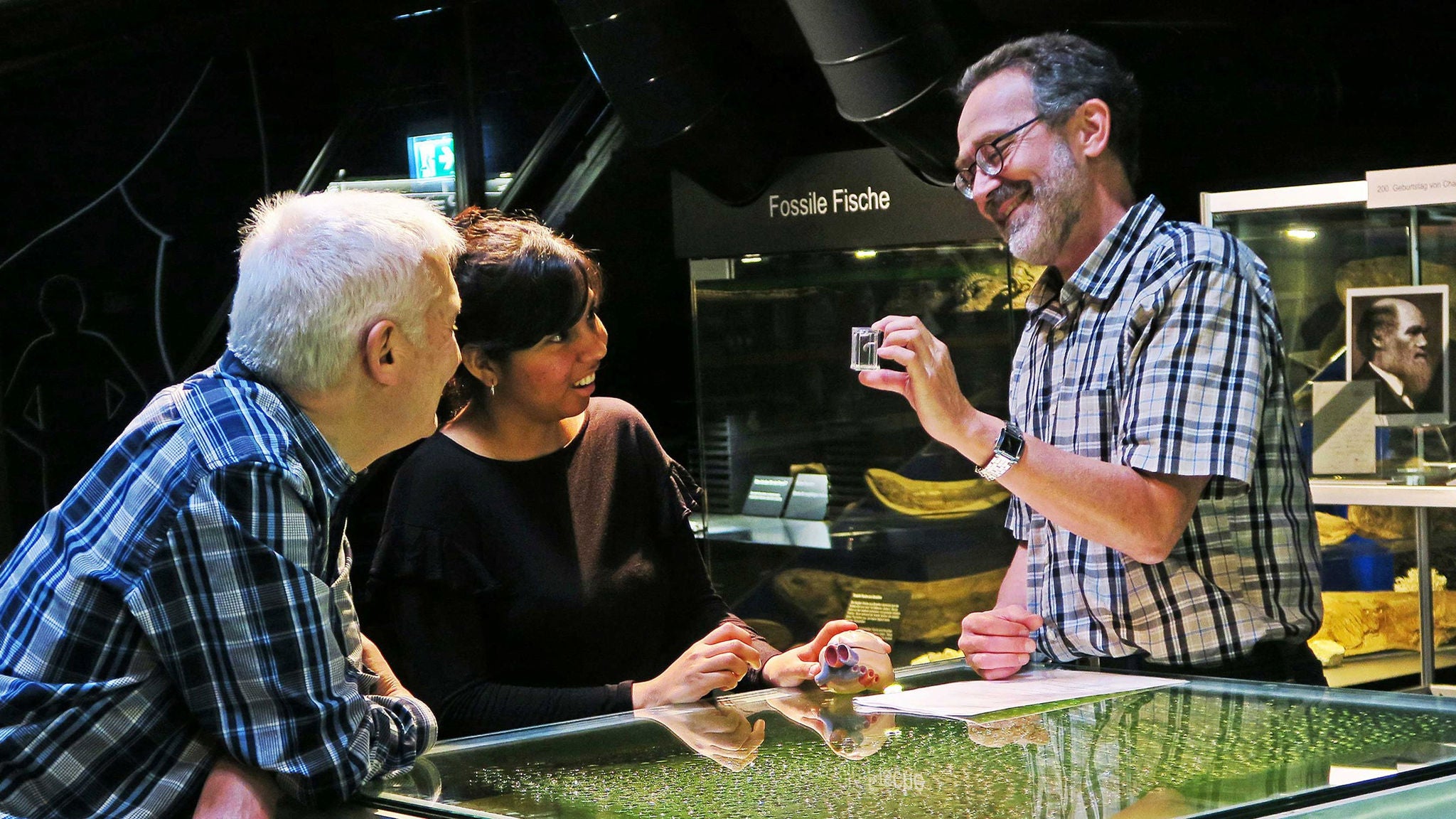 Zwei Personen bekommen ein Ausstellungsstück vom Kulturama erklärt. 