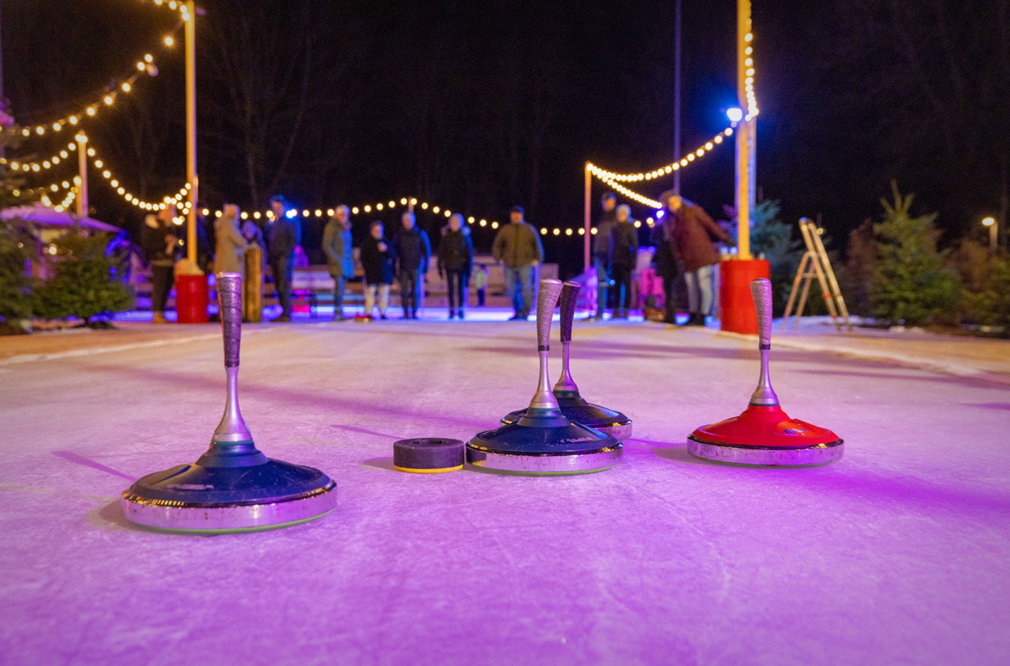 Eine Gruppe spielt Eisstockschiessen am Winterzauber Adliswil.