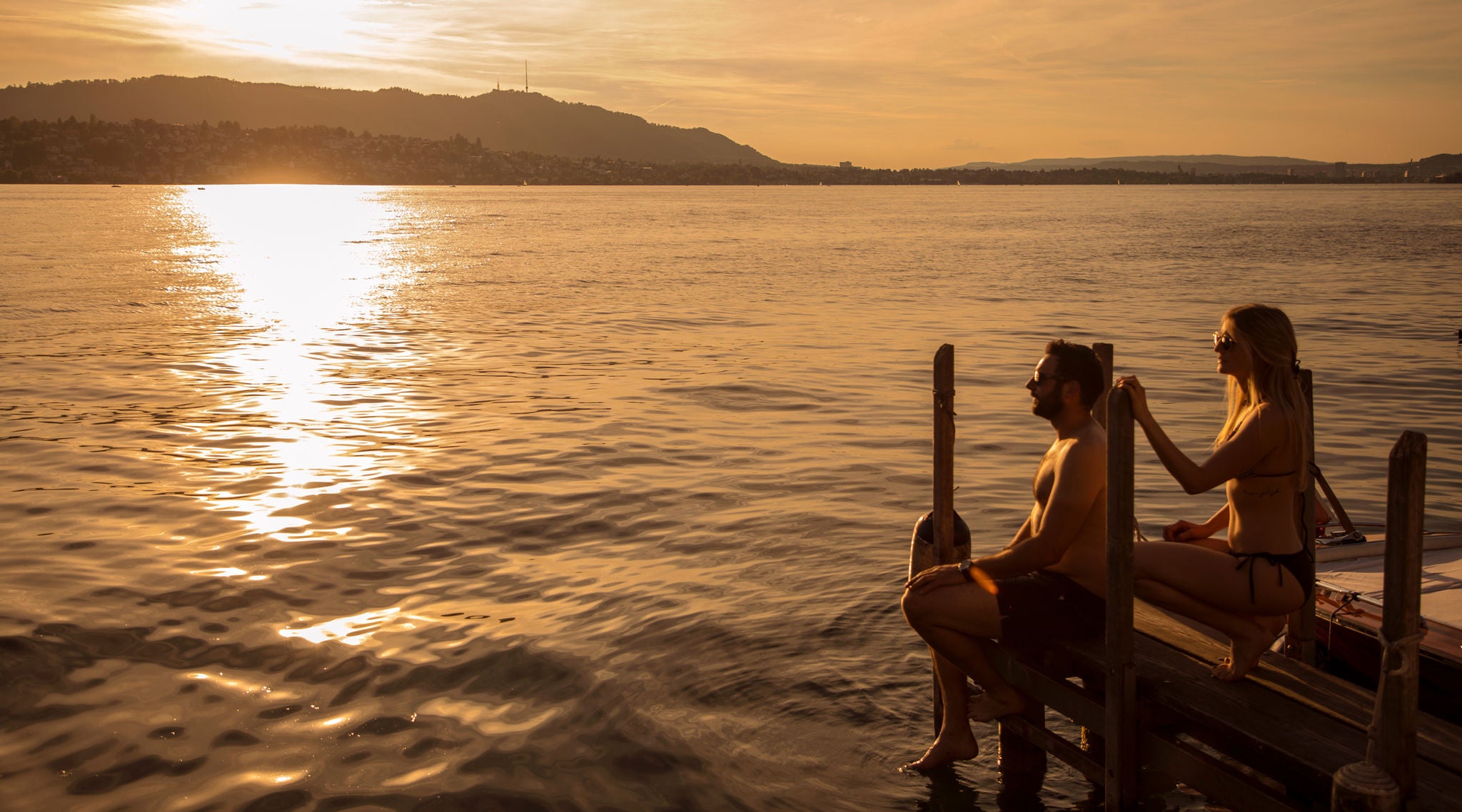 Frau und Mann bei Sonnenuntergang auf dem Steg beim Romantik Seehotel Sonne in Küsnacht