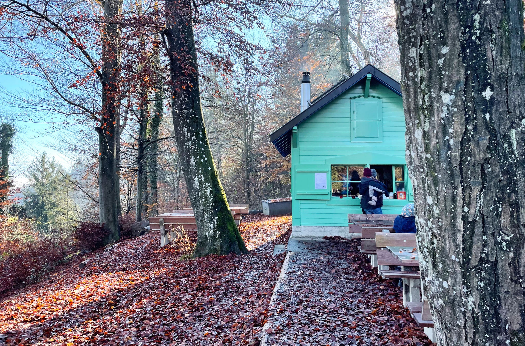 Gäste holen heissen Tee beim türkisen Teehüsli Hohenstein auf dem Uetliberg.