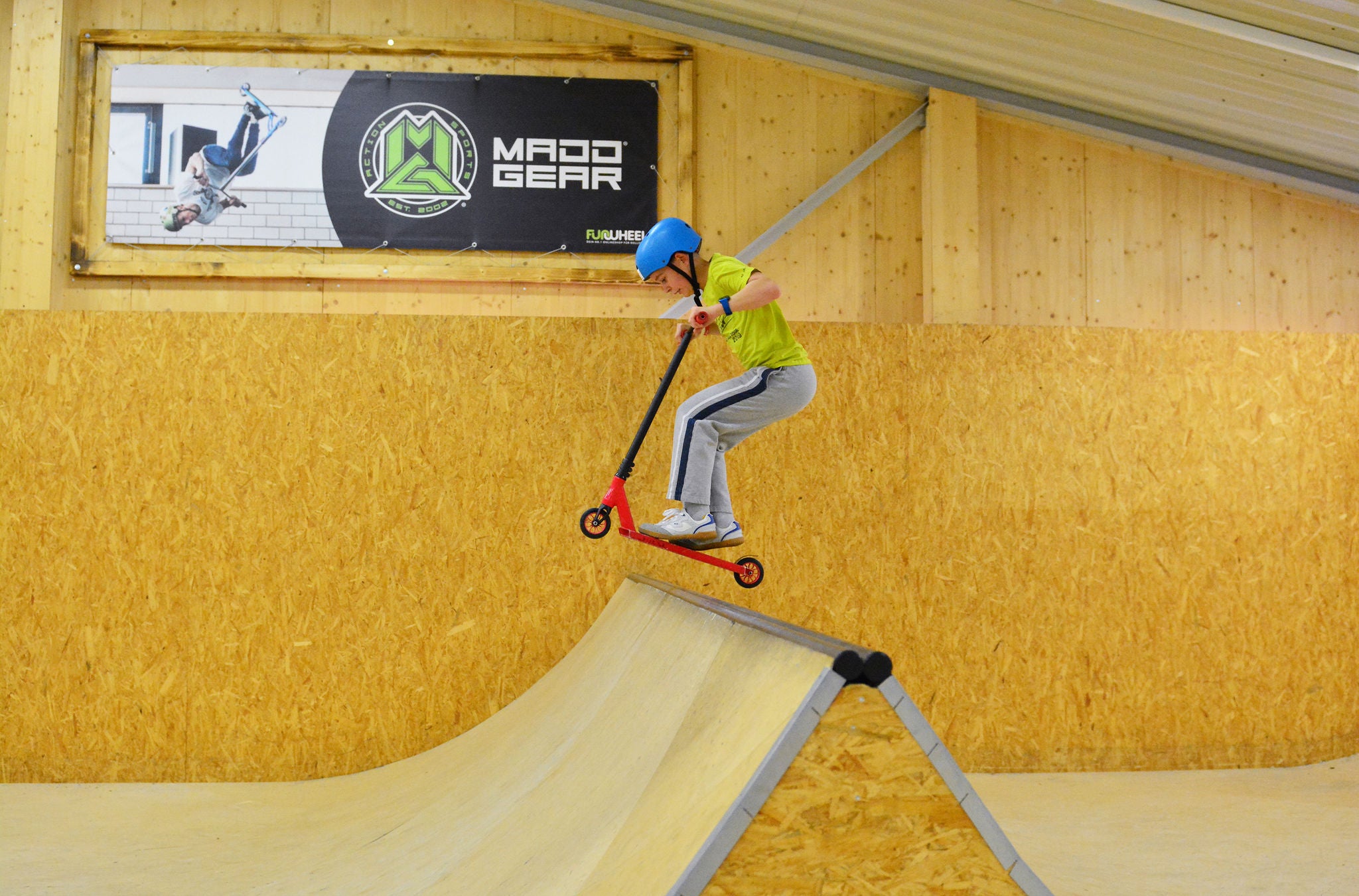 Ein Junge fährt mit dem Scooter über die Halfpipe im Geisterkickboarder GKB Skatepark in Wetzikon.