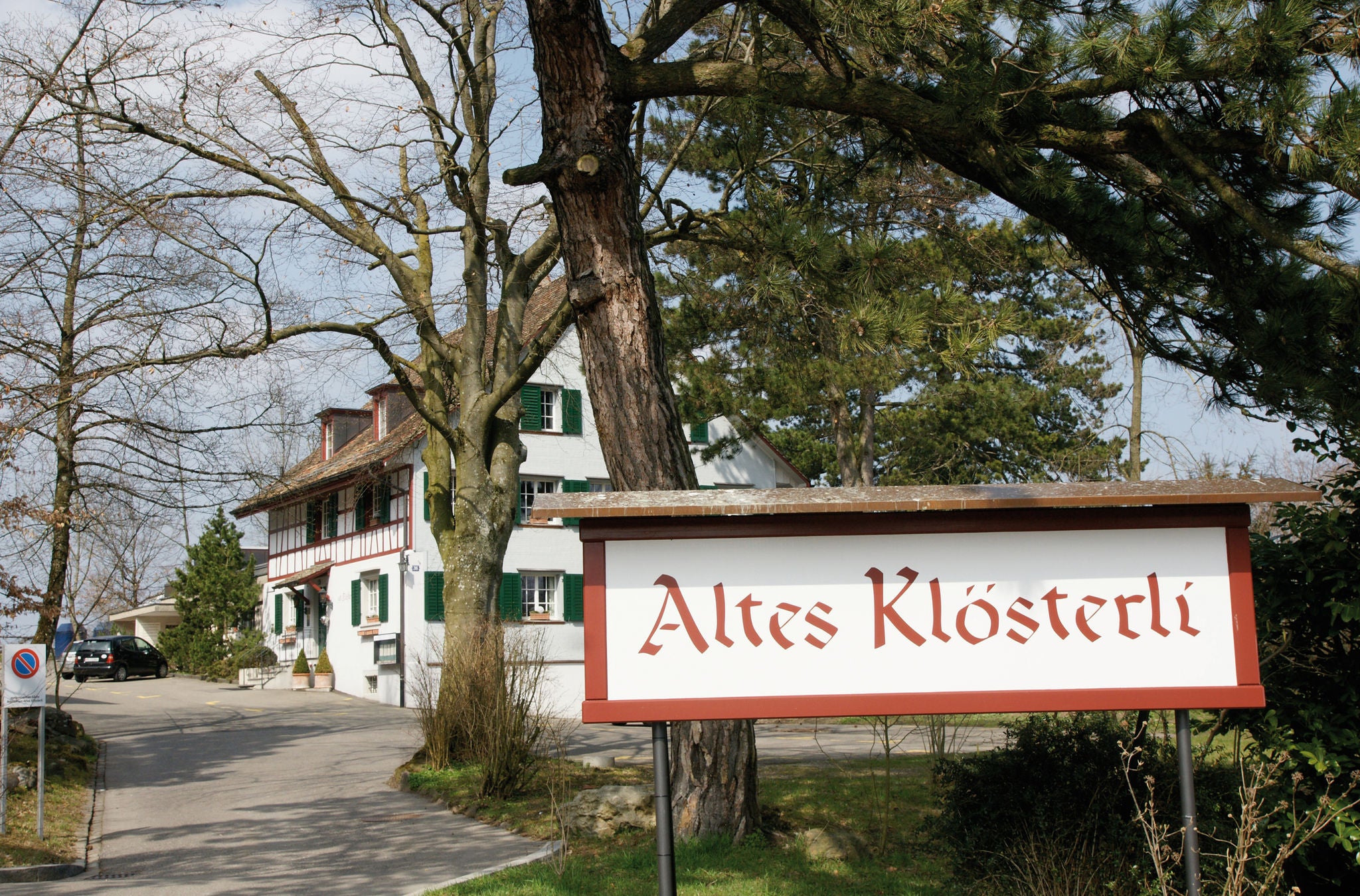 Ein altes Fachwerkhaus mit grossem Schild im Vordergrund, angeschrieben mit "Altes Klösterli"