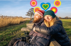 Freunde sitzen um einen Picknicktisch im Freien. 