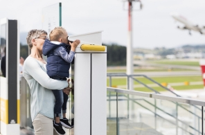 Mutter und Kind beobachten Flugzeuge am Flughafen Zürich